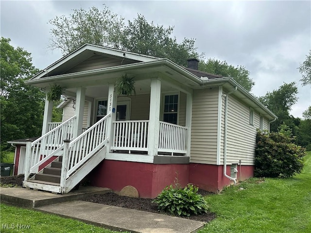5130 Winfield St NE, East Canton, OH 44730 - view of front of property featuring a porch, a chimney, and a front lawn