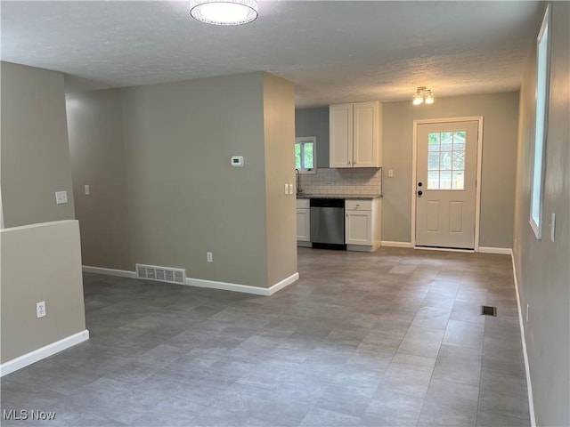 5482 Pleasant St, North Ridgeville, OH 44039 - kitchen featuring stainless steel dishwasher, a textured ceiling, white cabinets, and decorative backsplash