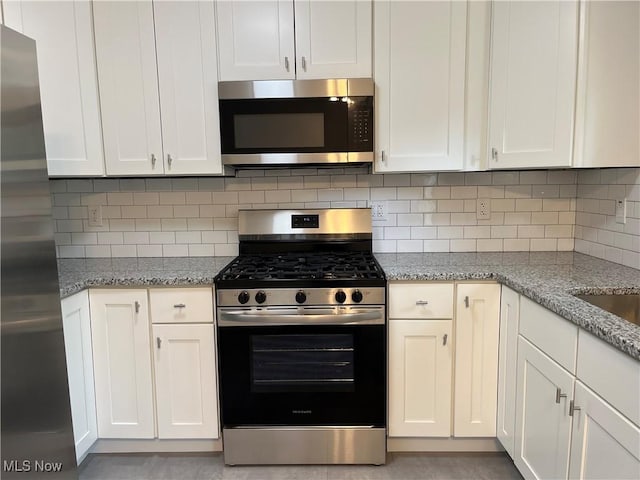 5482 Pleasant St, North Ridgeville, OH 44039 - kitchen with appliances with stainless steel finishes, white cabinets, and light stone countertops
