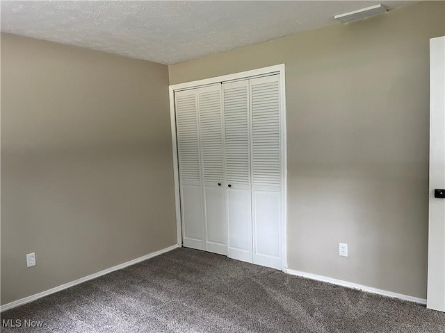 5482 Pleasant St, North Ridgeville, OH 44039 - unfurnished bedroom featuring dark carpet, a closet, and a textured ceiling