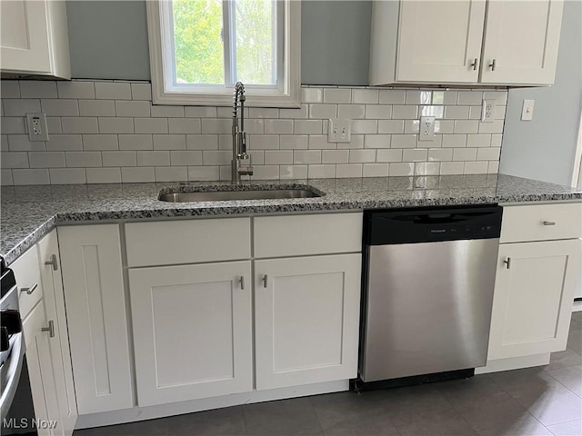 5482 Pleasant St, North Ridgeville, OH 44039 - kitchen featuring dishwasher, white cabinetry, decorative backsplash, light stone countertops, and dark tile patterned flooring