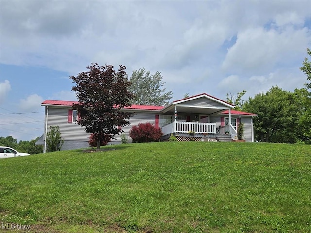 1947 N Vinegar Hill Rd NE, Mcconnelsville, OH 43756 - manufactured / mobile home featuring covered porch, a front lawn, and a metal roof