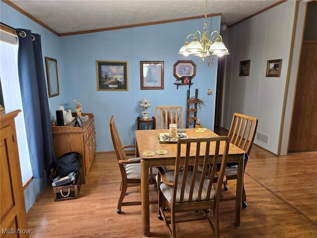 1947 N Vinegar Hill Rd NE, Mcconnelsville, OH 43756 - dining area featuring ornamental molding, light wood finished floors, a chandelier, and a textured ceiling