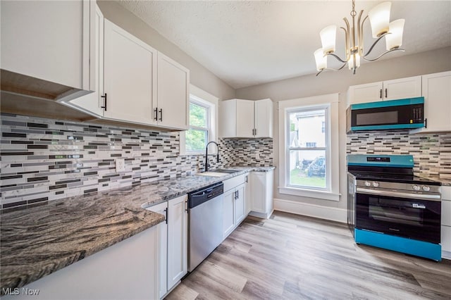 1115 W 43rd St, Ashtabula, OH 44004 - kitchen featuring stainless steel appliances, white cabinets, stone counters, light wood-style flooring, and backsplash