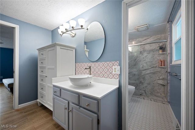 5802 Redwood Ct, Mentor-On-The-Lake, OH 44060 - bathroom featuring a marble finish shower, vanity, a textured ceiling, and wood finished floors