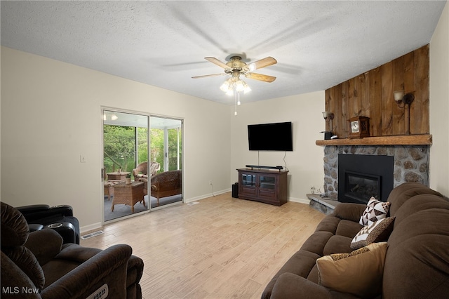 5802 Redwood Ct, Mentor-On-The-Lake, OH 44060 - living area with light wood-style floors, a ceiling fan, a fireplace, and a textured ceiling