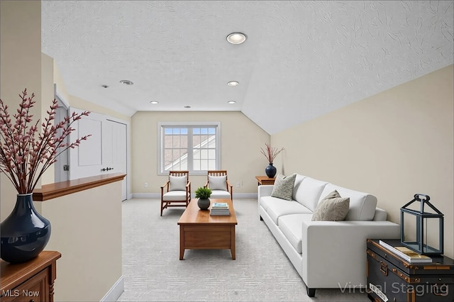 34782 Legends Way, Grafton, OH 44044 - living room with a textured ceiling, lofted ceiling, recessed lighting, and light colored carpet