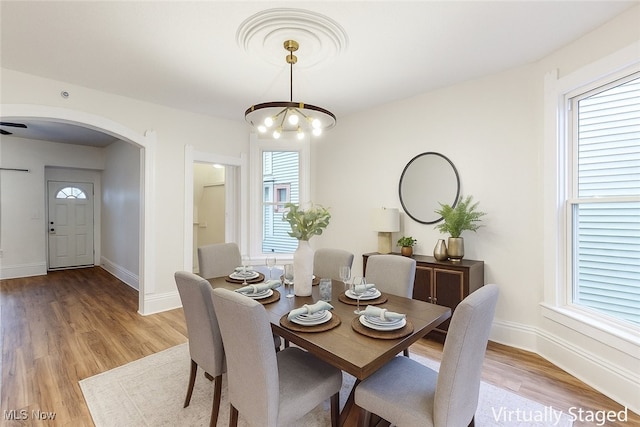 1851 W 52nd St, Cleveland, OH 44102 - dining room featuring a chandelier, healthy amount of natural light, arched walkways, and light wood-type flooring