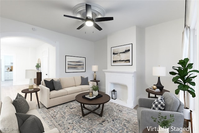1851 W 52nd St, Cleveland, OH 44102 - living room featuring arched walkways, a ceiling fan, and a fireplace with flush hearth