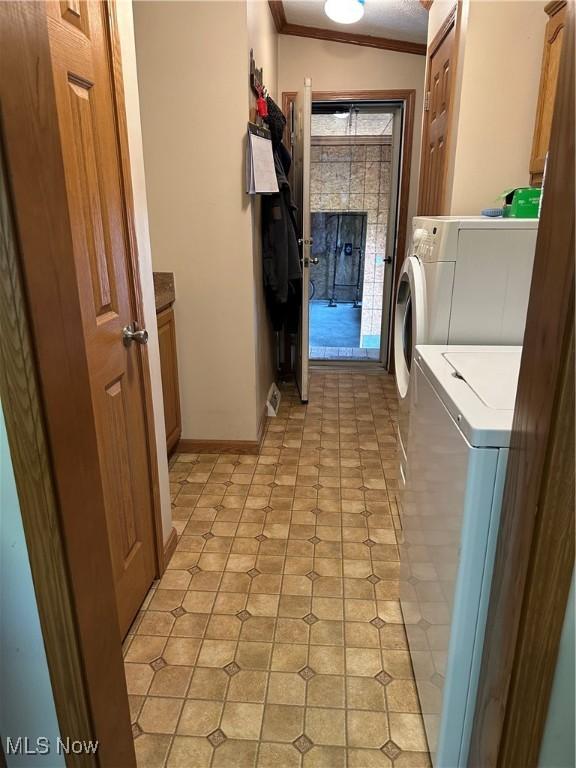 4182 Reger Rd, Conneaut, OH 44030 - laundry area with washer and clothes dryer, crown molding, and cabinet space