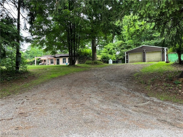 382 Bluestone Dr, Weirton, WV 26062 - view of front facade featuring an outbuilding, dirt driveway, and a detached garage