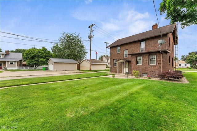119 5th St SW, Strasburg, OH 44680 - view of front of property featuring brick siding, a front yard, a chimney, and an outbuilding