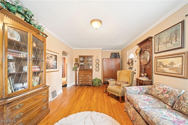 1499 Redwood Ave, Akron, OH 44301 - living room featuring light wood-style flooring, ornamental molding, and arched walkways
