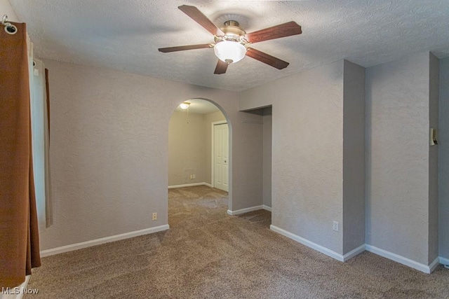 449 Westchester Dr SE, Warren, OH 44484 - carpeted spare room with arched walkways, a ceiling fan, a textured wall, and a textured ceiling