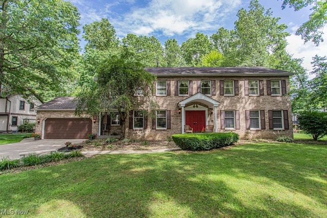 449 Westchester Dr SE, Warren, OH 44484 - colonial home with driveway, an attached garage, a front yard, and brick siding