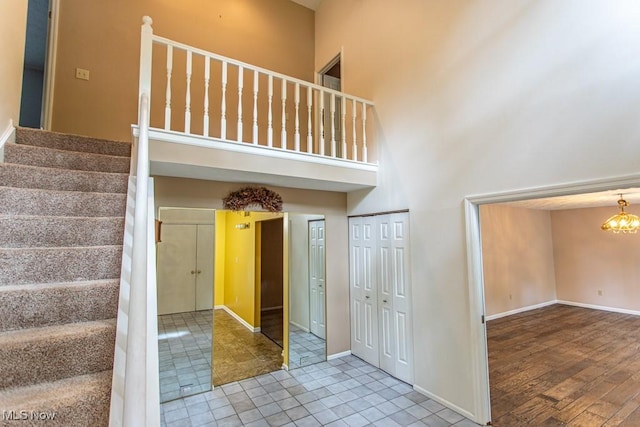 449 Westchester Dr SE, Warren, OH 44484 - stairs featuring a high ceiling, a chandelier, and tile patterned flooring