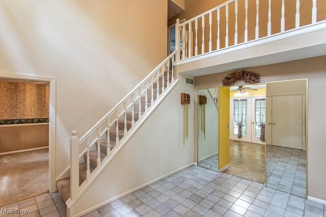 449 Westchester Dr SE, Warren, OH 44484 - stairway with a towering ceiling, a ceiling fan, and tile patterned floors