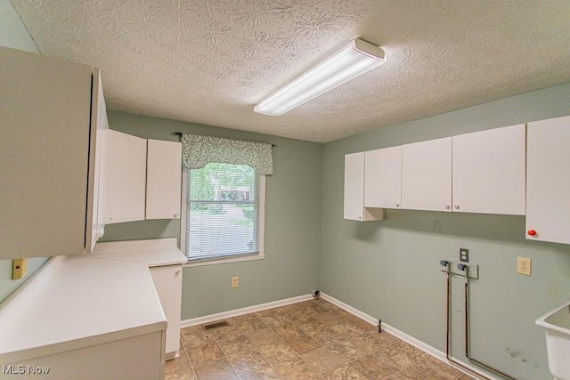 449 Westchester Dr SE, Warren, OH 44484 - laundry area with cabinet space, a textured ceiling, and hookup for a washing machine