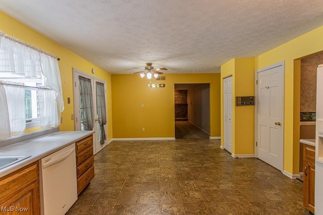 449 Westchester Dr SE, Warren, OH 44484 - kitchen with white dishwasher, ceiling fan, light countertops, a textured ceiling, and brown cabinetry