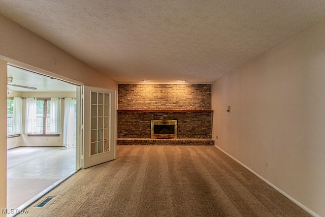 449 Westchester Dr SE, Warren, OH 44484 - unfurnished living room with a textured ceiling, carpet floors, and a brick fireplace