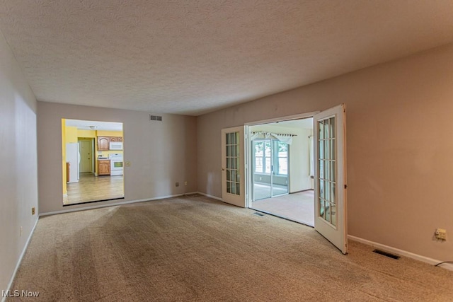 449 Westchester Dr SE, Warren, OH 44484 - empty room with carpet, french doors, and a textured ceiling