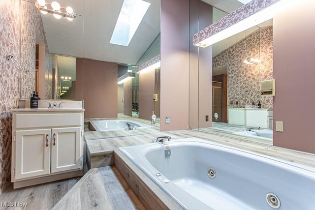 449 Westchester Dr SE, Warren, OH 44484 - bathroom with a skylight, vanity, a jetted tub, and vaulted ceiling