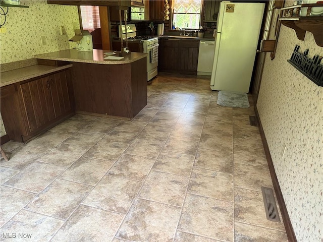 19693 Dudley Rd, Caldwell, OH 43724 - kitchen with white appliances, wallpapered walls, and a peninsula