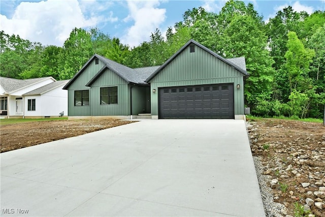 2320 Wilshire Dr, Cortland, OH 44410 - view of front of house with driveway, board and batten siding, a garage, and roof with shingles