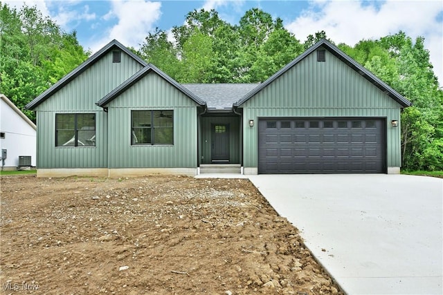 2320 Wilshire Dr, Cortland, OH 44410 - view of front of property with board and batten siding, driveway, an attached garage, and a shingled roof