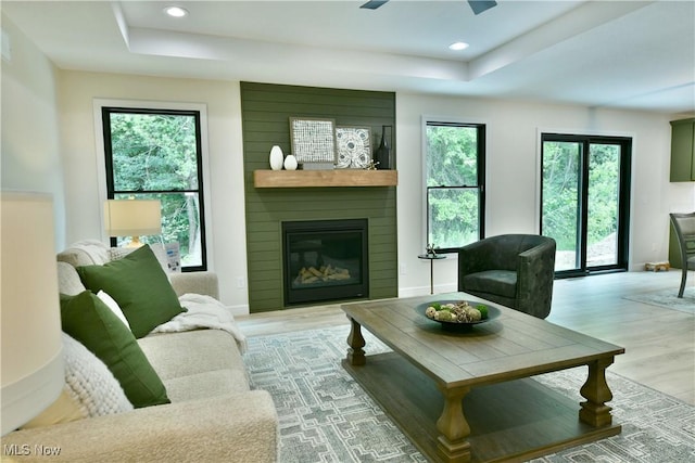 2320 Wilshire Dr, Cortland, OH 44410 - living room featuring a tray ceiling, light wood-type flooring, a fireplace, a ceiling fan, and recessed lighting