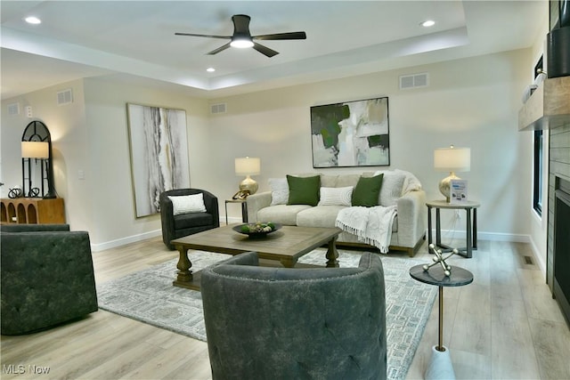 2320 Wilshire Dr, Cortland, OH 44410 - living area with a tray ceiling, a fireplace, light wood-type flooring, ceiling fan, and recessed lighting