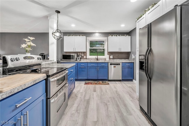 6118 Echodell Ave NW, North Canton, OH 44720 - kitchen featuring stainless steel appliances, blue cabinetry, white cabinets, light countertops, and recessed lighting