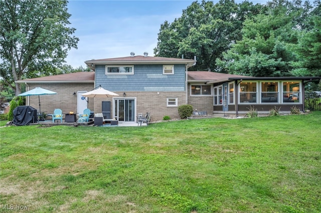 6118 Echodell Ave NW, North Canton, OH 44720 - rear view of property featuring a sunroom, a yard, brick siding, and a patio