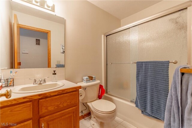 10393 Scotney Ave NW, North Canton, OH 44720 - full bathroom featuring vanity, tile patterned flooring, and shower / bath combination with glass door