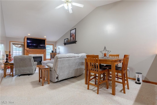 10393 Scotney Ave NW, North Canton, OH 44720 - dining room featuring lofted ceiling, a glass covered fireplace, ceiling fan, and light colored carpet