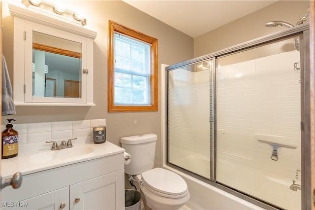 10393 Scotney Ave NW, North Canton, OH 44720 - bathroom featuring vanity, bath / shower combo with glass door, and tasteful backsplash