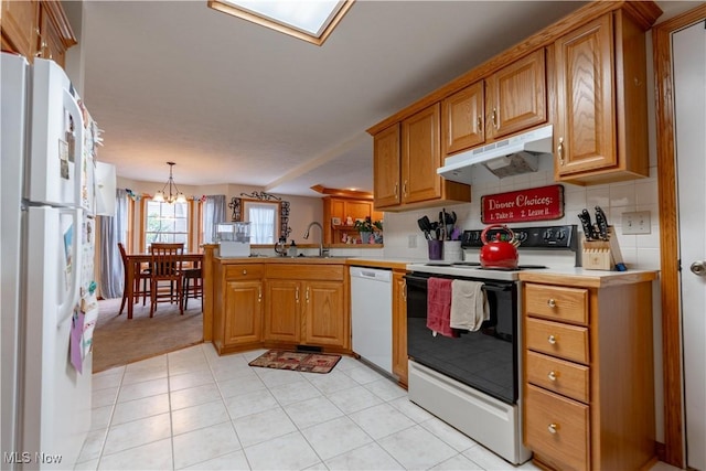 10393 Scotney Ave NW, North Canton, OH 44720 - kitchen featuring white appliances, under cabinet range hood, a peninsula, light countertops, and brown cabinets