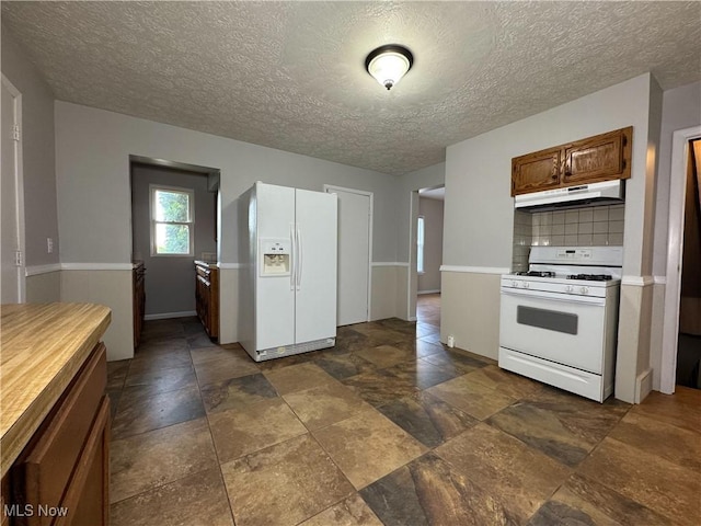 101 Ridgeway St, Struthers, OH 44471 - kitchen featuring white appliances, under cabinet range hood, dark stone finish flooring, a textured ceiling, and decorative backsplash