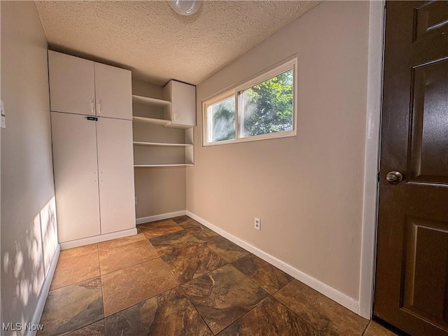 101 Ridgeway St, Struthers, OH 44471 - unfurnished bedroom featuring a textured ceiling, stone finish floors, and a closet