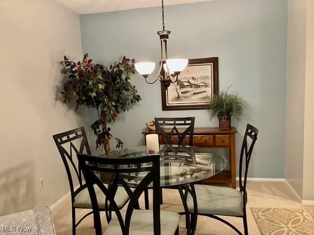 625 Canterbury Ln Unit 27A, Medina, OH 44256 - carpeted dining space featuring a chandelier and baseboards