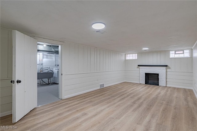 3886 Faversham Rd, University Heights, OH 44118 - basement with light wood-style floors, a fireplace, washer / clothes dryer, and plenty of natural light