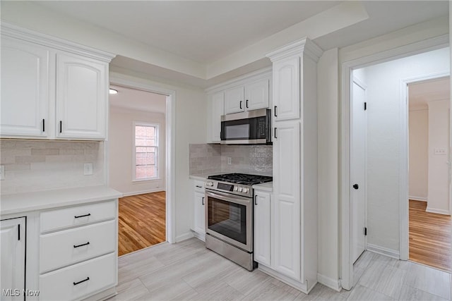 3886 Faversham Rd, University Heights, OH 44118 - kitchen with appliances with stainless steel finishes, white cabinetry, light countertops, and tasteful backsplash