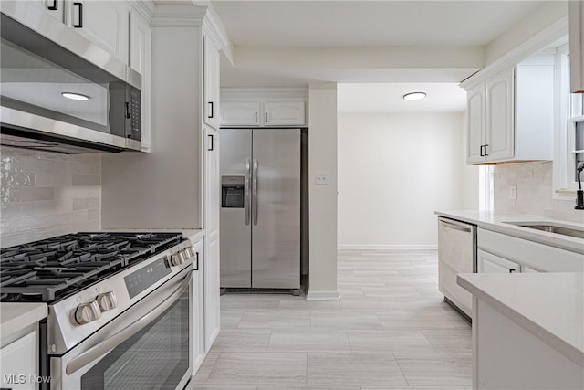 3886 Faversham Rd, University Heights, OH 44118 - kitchen featuring appliances with stainless steel finishes, light countertops, white cabinets, decorative backsplash, and recessed lighting