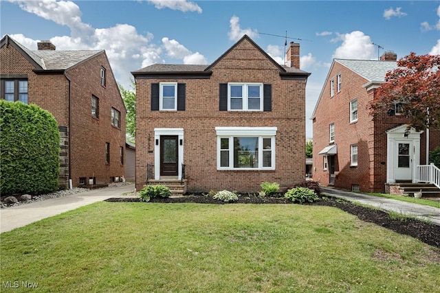 3886 Faversham Rd, University Heights, OH 44118 - traditional home featuring brick siding, a front lawn, and a chimney