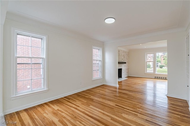 3886 Faversham Rd, University Heights, OH 44118 - unfurnished living room with light wood-type flooring, ornamental molding, and a fireplace