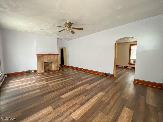 1874 Idaho Ave, East Liverpool, OH 43920 - unfurnished living room with arched walkways, a ceiling fan, wood finished floors, and a fireplace