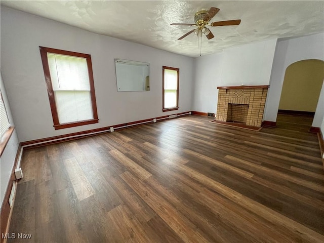 1874 Idaho Ave, East Liverpool, OH 43920 - unfurnished living room featuring ceiling fan, arched walkways, wood finished floors, and a fireplace