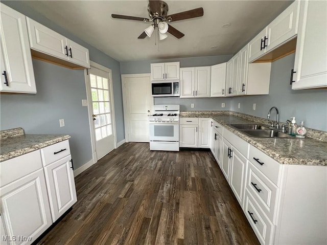 1874 Idaho Ave, East Liverpool, OH 43920 - kitchen featuring gas range gas stove, a ceiling fan, dark wood finished floors, and white cabinets