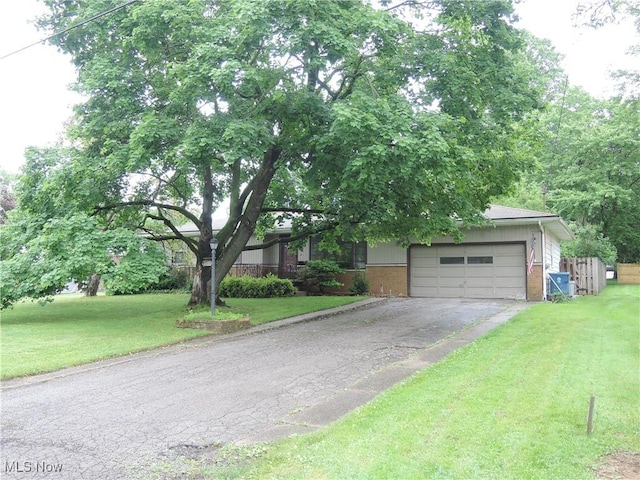 7277 Clovermeade Ave, Youngstown, OH 44514 - view of property hidden behind natural elements featuring brick siding, asphalt driveway, an attached garage, and a front yard