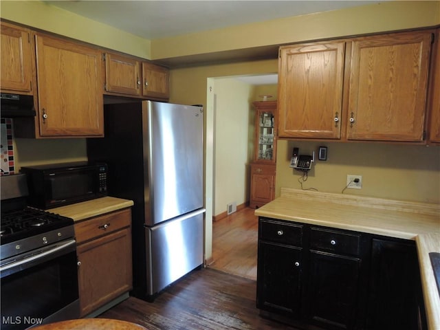 7277 Clovermeade Ave, Youngstown, OH 44514 - kitchen featuring stainless steel appliances, dark wood-style floors, light countertops, and ventilation hood